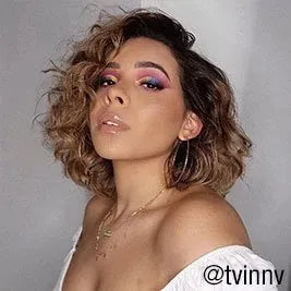 Woman with curly shoulder-length hair and bold colorful eye makeup @tvinny